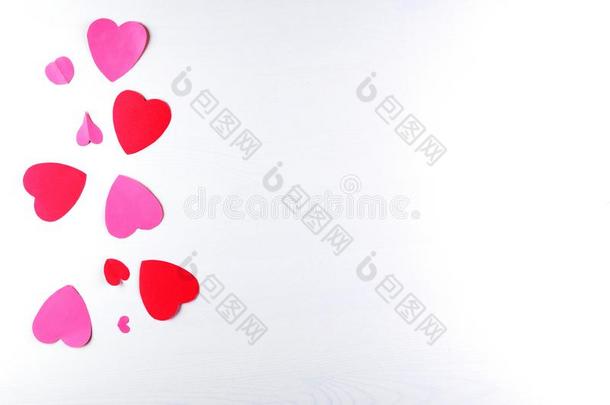 手-使粉红色的爱心和赠品盒向白色的木制的质地