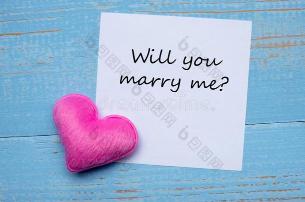 你愿意结婚我?单词向纸笔记和粉红色的心形状装饰