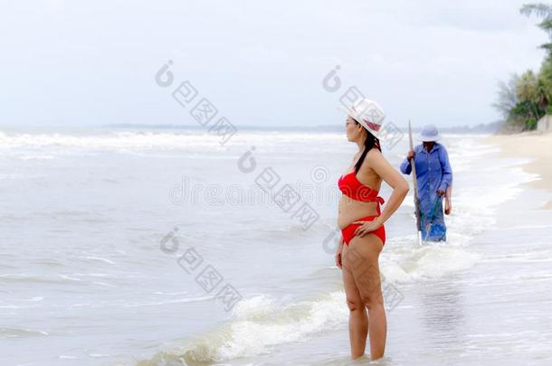 女人形状漂亮的和<strong>红色</strong>的<strong>比基尼</strong>式游泳衣和帽子向海滩