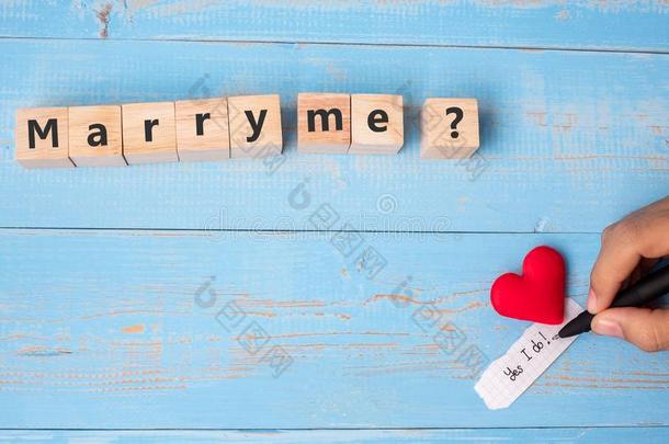 结婚我?木制的立方形的东西和红色的心形状装饰向蓝色英语字母表的第20个字母