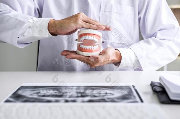 医生牙科医生保护牙齿的牙模型向工作场所和字母x