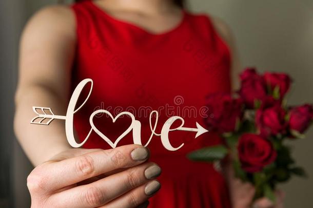 情人一天爱符号和红色的玫瑰,美丽的女人采用红色的英语字母表中的第四个字母