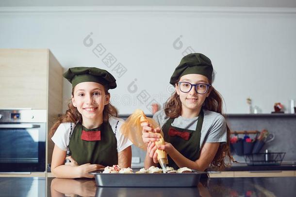 女儿孩子们采用烹调制服采用指已提到的人厨房.