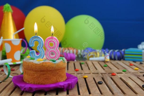 生日38蛋糕和蜡烛向乡村的木制的表和后面