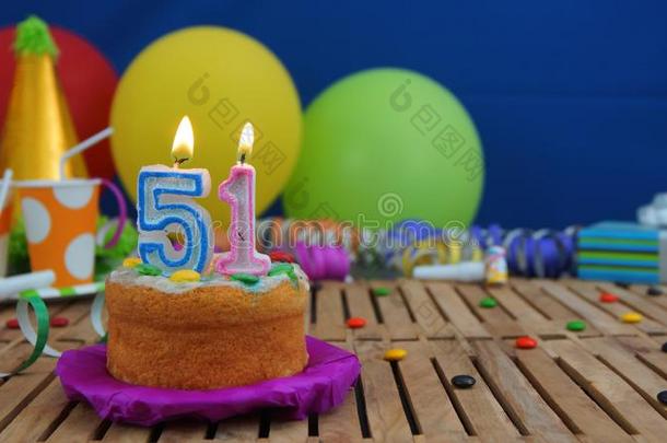 生日<strong>51</strong>蛋糕和蜡烛向乡村的木制的表和后面