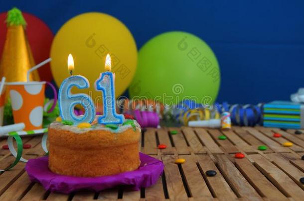 生日<strong>61</strong>蛋糕和蜡烛向乡村的木制的表和后面