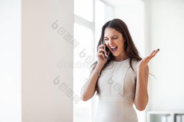 幸福的美丽的女人尖叫~发出尖叫声采用可移动的电话