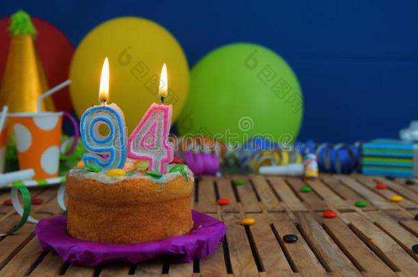 生日94蛋糕和蜡烛向乡村的木制的表和后面