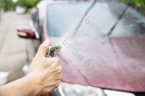 男人洗涤汽车使用洗发剂和水