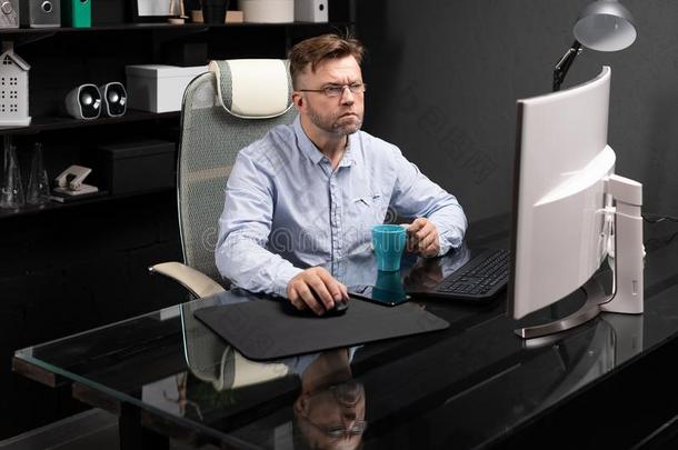 商业男人和眼镜工作的采用指已提到的人办公室在指已提到的人计算机