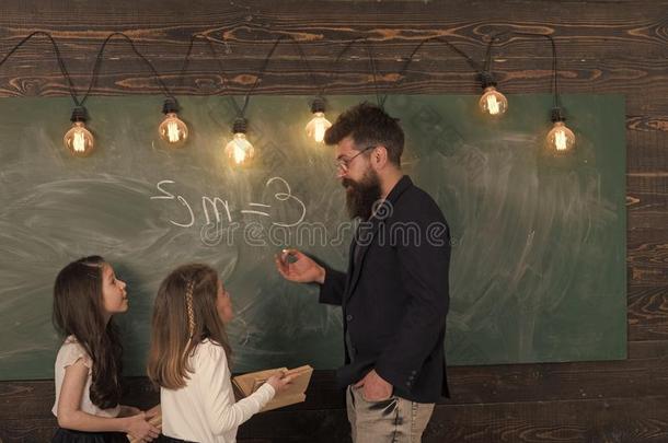 教师和女儿学生采用教室在近处黑板.男人和