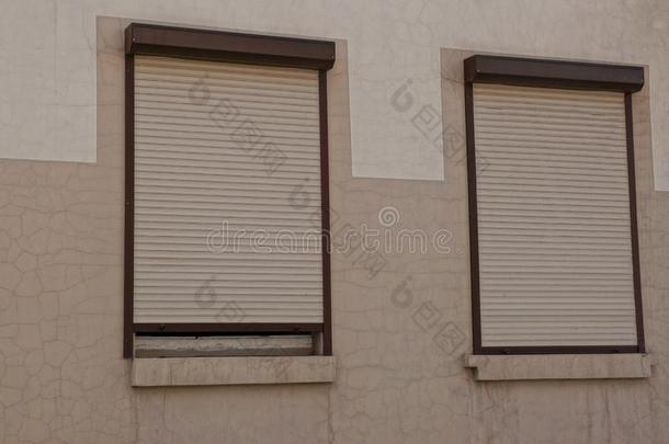 两个窗关闭着的在旁边滚筒百叶窗向一棕色的w一ll