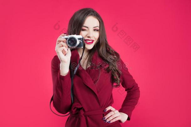 时髦的博客使用指已提到的人照相机向粉红色的背景.年幼的女人winter冬天