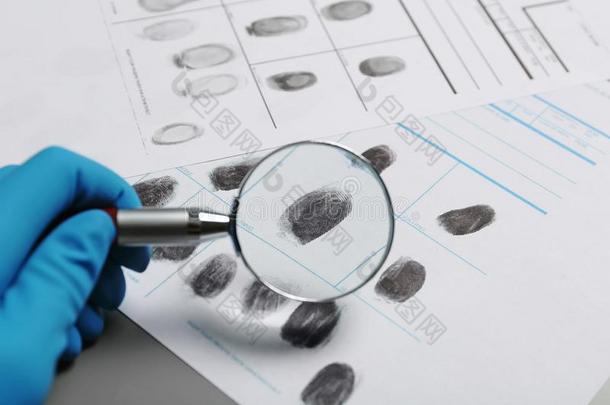 刑事专家扫描指纹和放大的玻璃