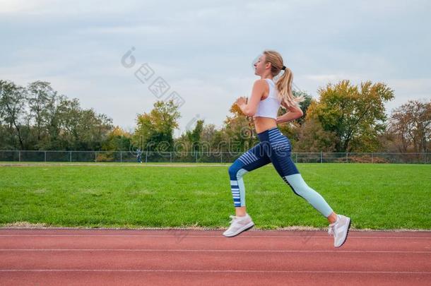 运动员的女人跑步向体育运动赛跑小路