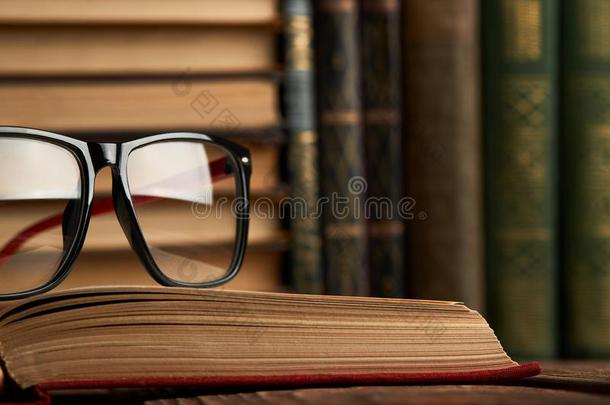 老的书和阅读眼镜向书桌采用图书馆房间