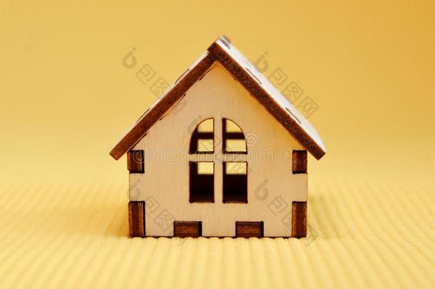 木制的玩具房屋模型向黄色的背景fr向t看法