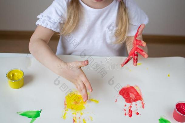 高加索人小的女孩绘画和富有色彩的手绘画颜料在homonym同音异义词