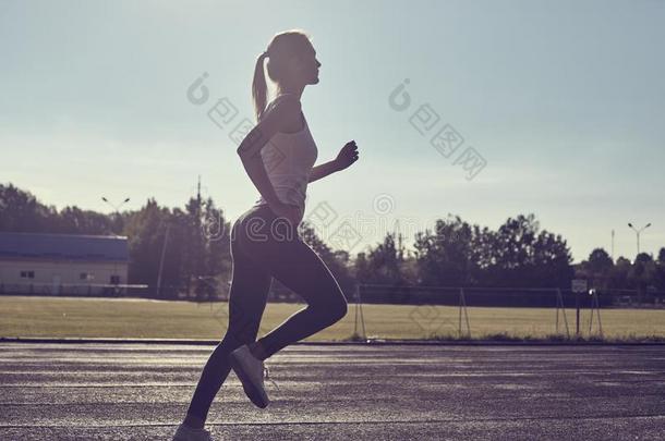 漂亮的女人慢跑在公园采用日出光