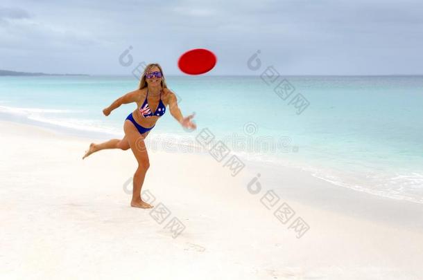 活泼的澳大利亚人女孩演奏飞盘田园诗般的海滩天堂