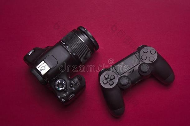游戏手柄和单眼数位相机照相机向红色的背景