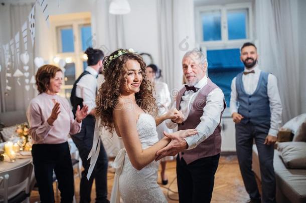 一年幼的新娘跳舞和祖父和别的客人向一嫁