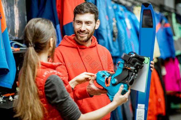 男人和女人挑选滑雪设备采用指已提到的人商店