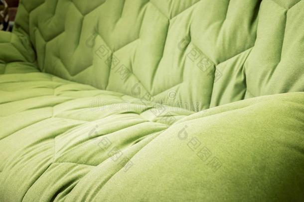关-在上面舒适的绿色的软的沙发和有卷发的用U字钉钉箱.脉冲编码装置