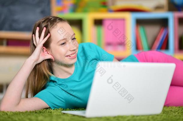 肖像关于漂亮的女孩和便携式电脑计算机向地面