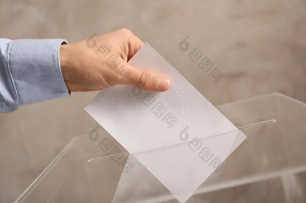 男人放置他的投票进入中投票盒向颜色背景