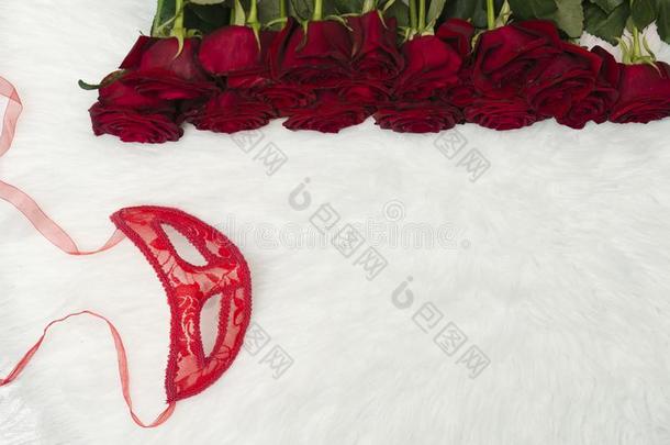 浪漫的狂欢节观念.红色的狂欢节面具和一花束关于关于