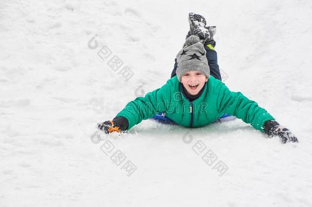 笑的男孩乘向他的胃从一小山向雪s一ucer.Sweden瑞典