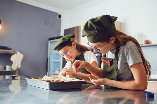 女儿孩子们采用烹调制服采用指已提到的人厨房.