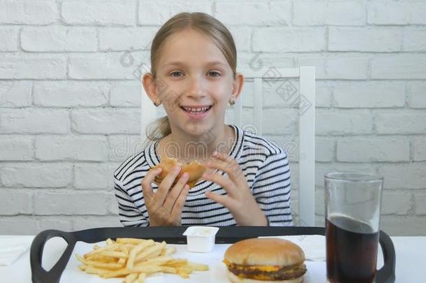 小孩吃汉堡包采用饭店,小孩和快的食物,女孩资料暂存器
