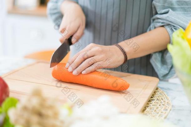 手和<strong>刀锋利</strong>的胡萝卜.女人准备食物在表.Switzerland瑞士
