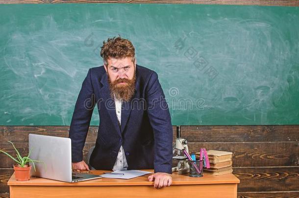 教师精确的严肃的有胡须的男人倾斜向表黑板背