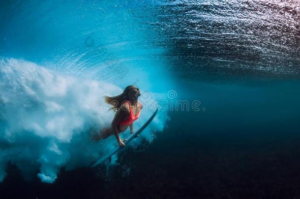 有魅力的冲浪运动员女人潜水在水中的和大的波浪