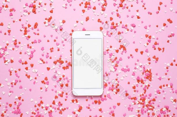 可移动的电话和粉红色的和红色的心向粉红色的背景