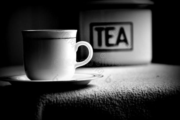 中国人茶水和茶水叶子从锡和白色的杯子和茶杯托向英语字母表中的第四个字母