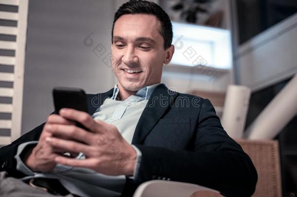 高兴的快乐的商人使用他的现代的智能手机