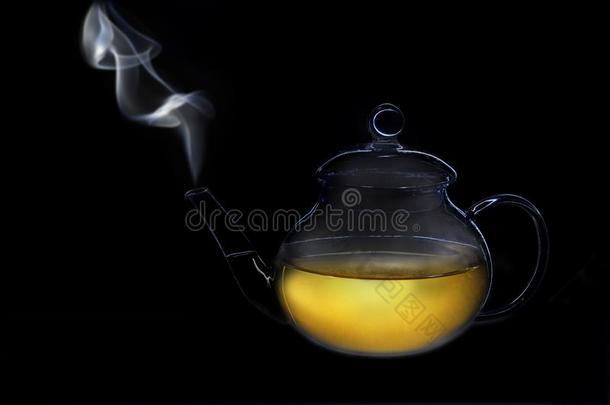 透明的玻璃茶壶和烟从指已提到的人喷口