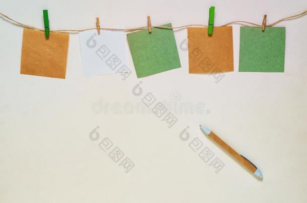 牛皮纸和白色的纸有背胶的标签和晒衣绳上夹衣服之夹子向一粗绳