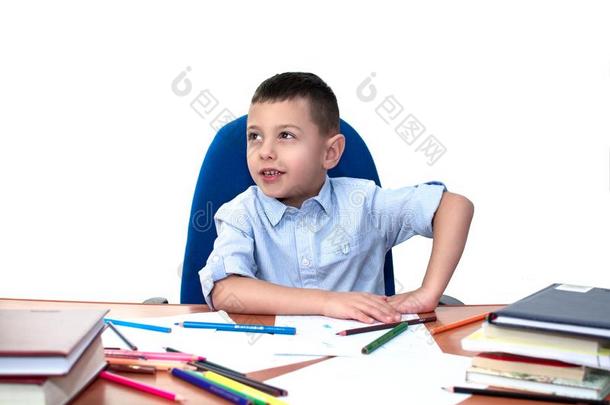一小的男孩关于学校年龄坐在一t一ble和笔记簿一ndbowel肠