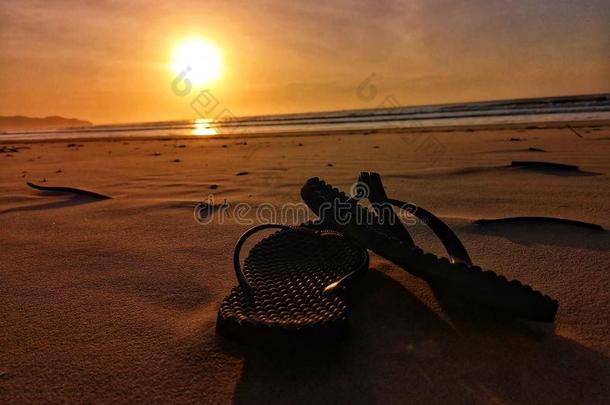 美丽的日落和凉鞋向指已提到的人海滩.