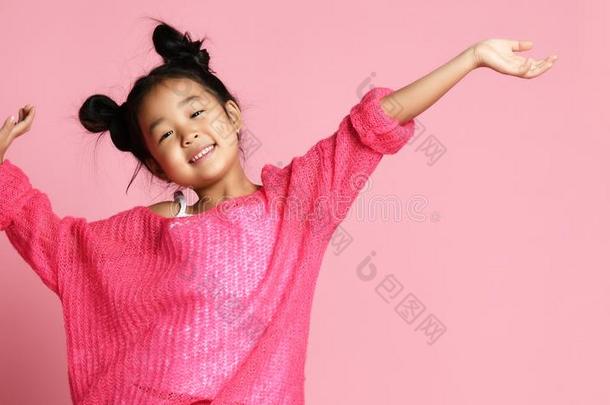 亚洲人小孩女孩采用p采用k毛衣,白色的短裤和有趣的圆形的小面包或点心st和