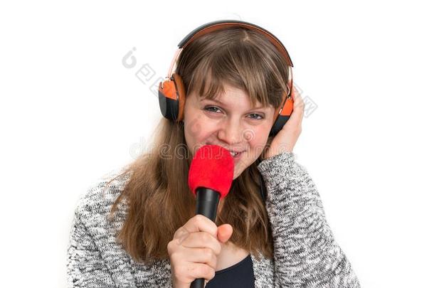 女人和microphone麦克风和耳机是（be的三单形式记录她歌曲