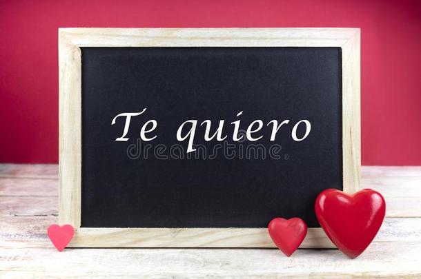 木制的黑板和红色的心和书面的句子采用西班牙人