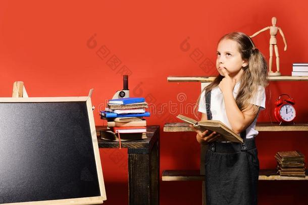 女孩保存敞开的书和st和s在旁边空白的黑板