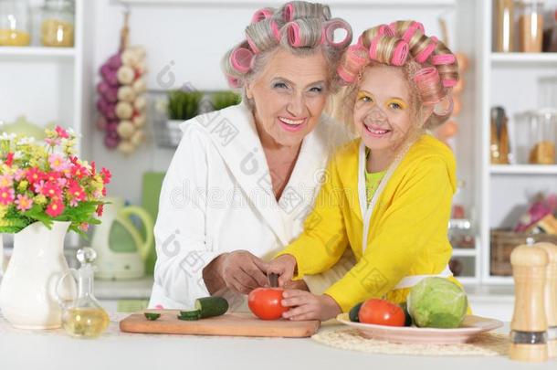 较高的女人和gr和daughter烹饪术在厨房