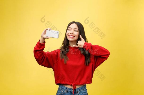 微笑的年幼的女孩制造自拍照照片向smartph向e越过黄色的